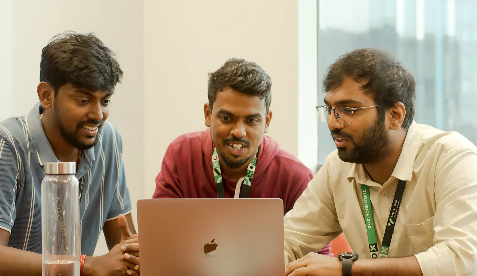 Three VGTS colleagues collaborating around a laptop