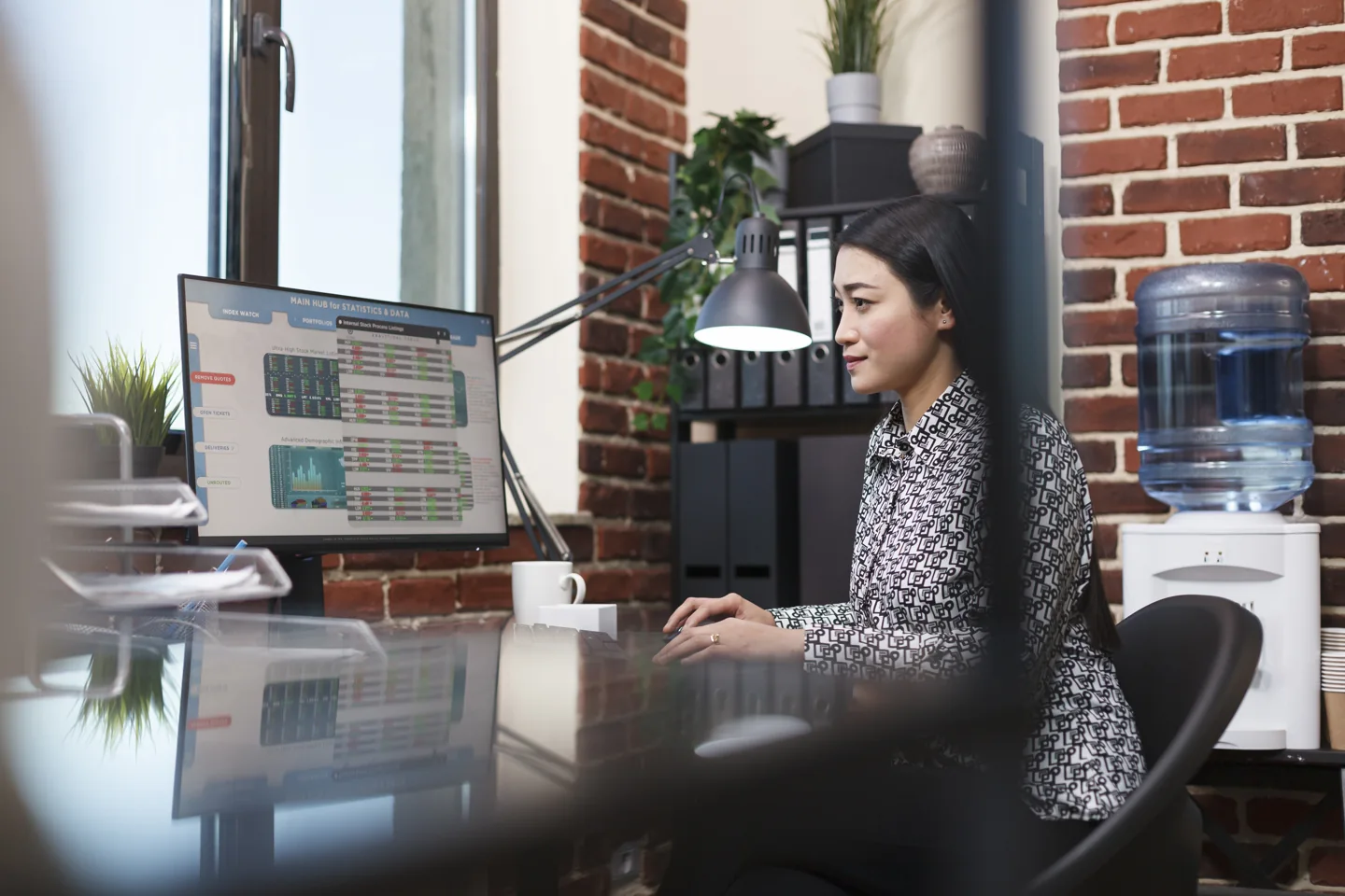 Stock photograph of a finance analyst reviewing a spreadsheet at a desktop computer