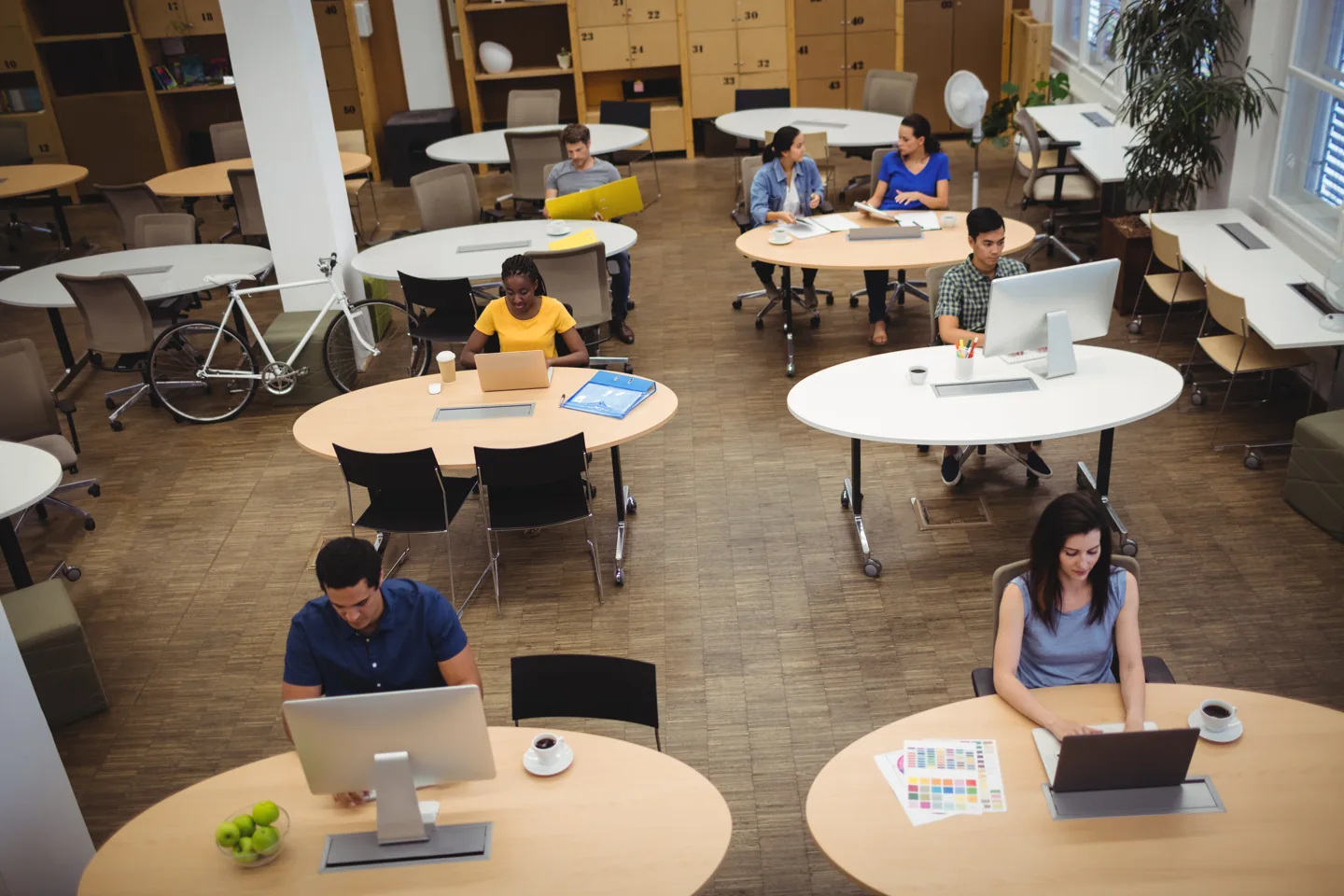 Stock photograph of people working at separate desks in an open-plan studio